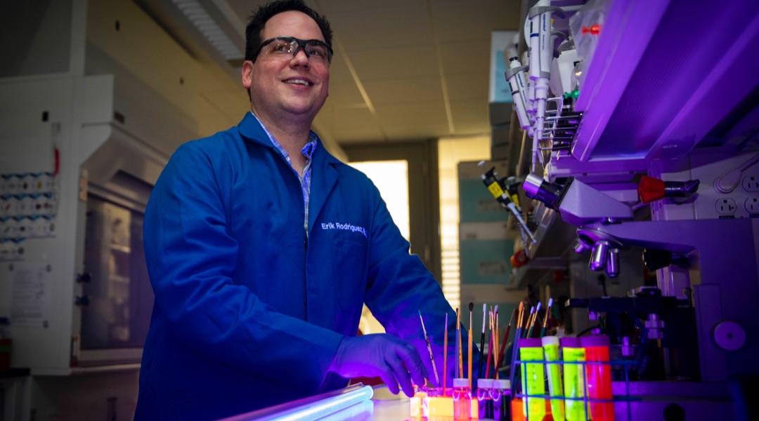 Male researcher in a lab using black lights 